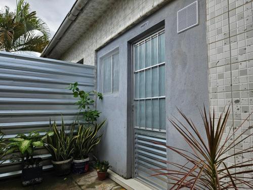a gray house with plants next to a fence at Suite 1 - Centro de Convenções700m, AC, WIFI in Recife