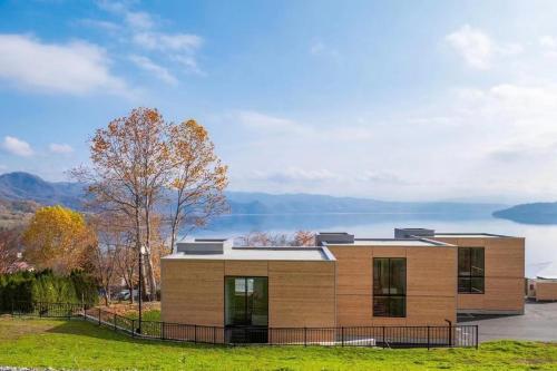 a house with a view of the water at WE Hotel Toya in Lake Toya