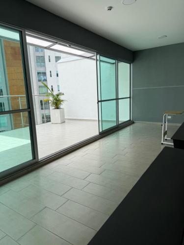 an empty room with large windows in a building at Apartamento en zona exclusiva del norte de Armenia Belmonte studio in Armenia