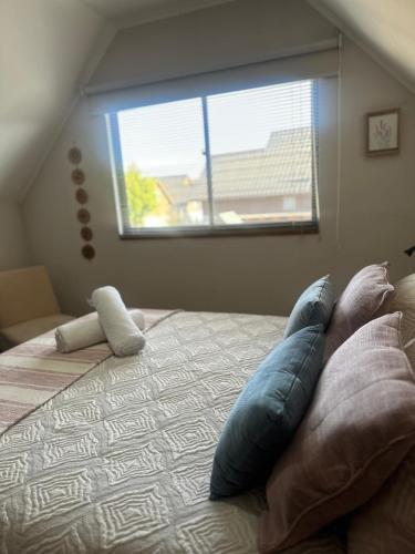 a bedroom with a bed with pillows and a window at Casa hacienda in Los Ángeles