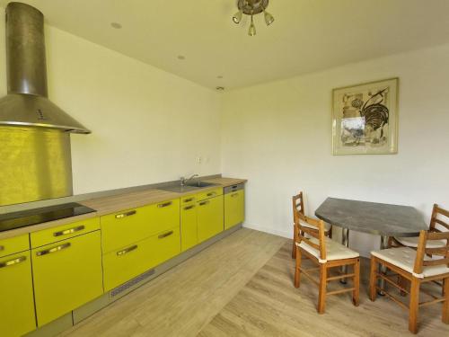 kuchnia z żółtymi szafkami i stołem z krzesłami w obiekcie Breton cottage, 500 m beach, Penvénan, Pink Granite Coast-ex TUI w mieście Penvénan