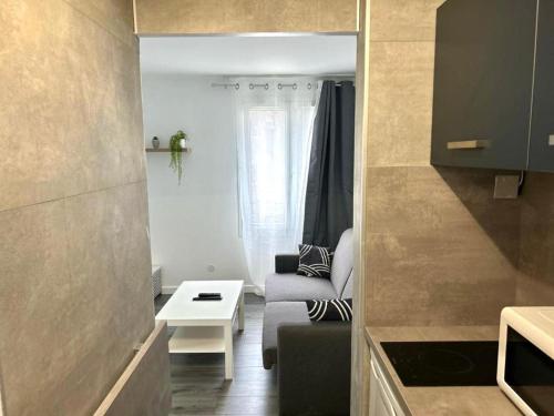 un petit salon avec un canapé et une table dans l'établissement STUDIO - 4pers PROCHE GARE 10 MIN DISNEY, à Bussy-Saint-Georges