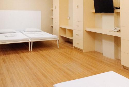 a room with a bed and wooden floors and cabinets at RedDoorz @ Southern Suites Guimaras in Oracon