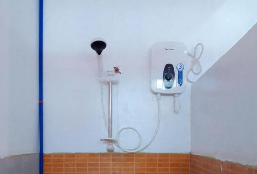 a shower in a bathroom with a hair dryer on the wall at RedDoorz @ Southern Suites Guimaras in Oracon