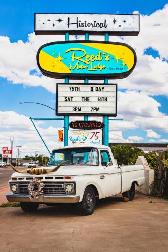 a white truck parked in front of a sign at Reeds Lodge in Springerville