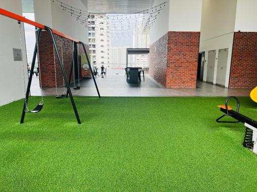 a gym with green flooring in a building at Chamber KL Residence by Moon Orchid in Kuala Lumpur