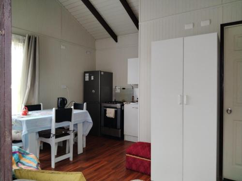 a kitchen and dining room with a table and a table and chairs at Refugio Pradera del Sur in Llanquihue
