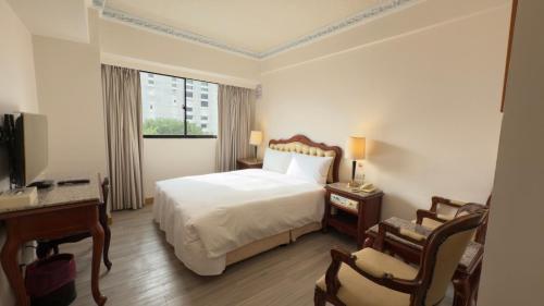 a hotel room with a bed and a desk at Hua Tong Hotel in Hualien City