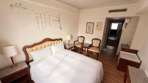 a bedroom with a bed and a table and chairs at Hua Tong Hotel in Hualien City