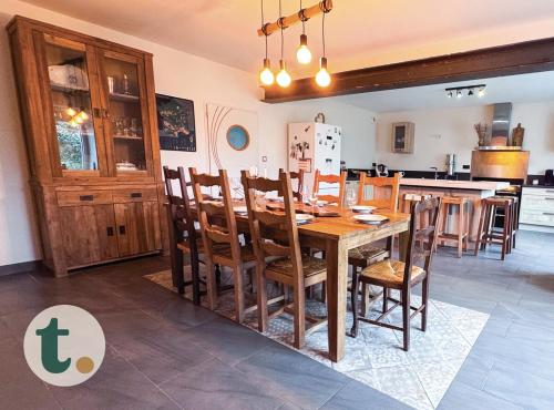 une cuisine et une salle à manger avec une table et des chaises en bois dans l'établissement Tranquiloue - Maison spacieuse à 8min du PuyduFou, à Saint-Laurent-sur-Sèvre