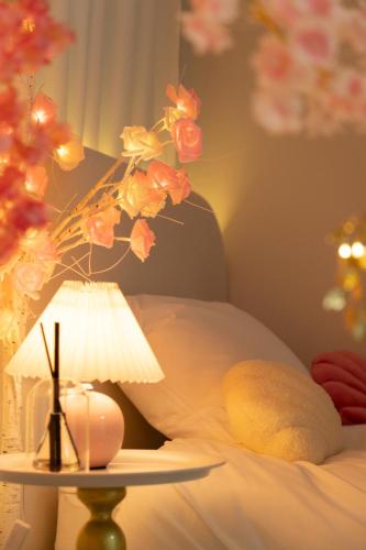 a lamp on a table next to a bed with flowers at DDM Stay 동대문 스테이 in Seoul