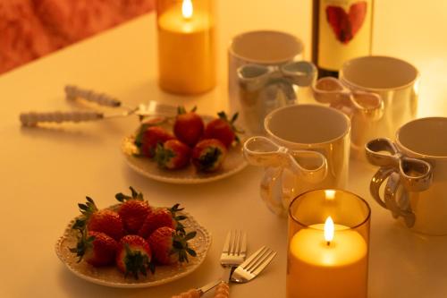a table with two plates of strawberries and candles at DDM Stay 동대문 스테이 in Seoul