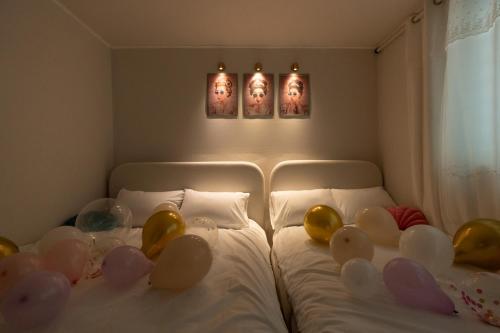 a bedroom with two beds with balloons on them at DDM Stay 동대문 스테이 in Seoul