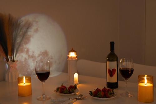 a table with two glasses of wine and candles at DDM Stay 동대문 스테이 in Seoul