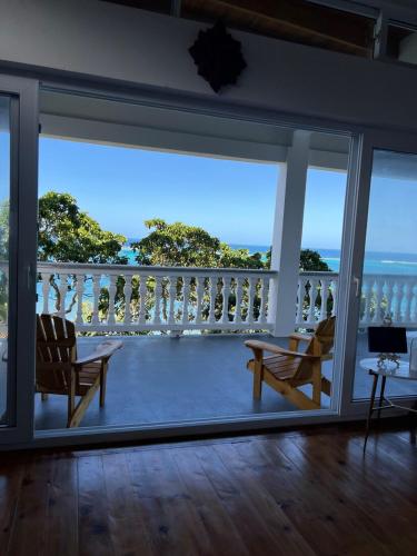 a room with a balcony with a view of the ocean at Casa De Arte, Roatan - Beachside Bliss in Camp Bay