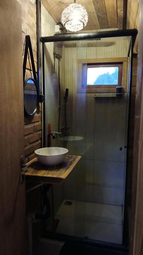 a bathroom with a sink and a glass shower at Cabana Villa Caju in Praia dos Algodões