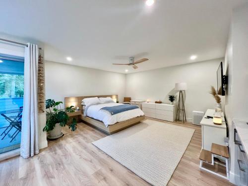 a bedroom with a bed and a large window at The Low Tide Suite in Nanoose Bay