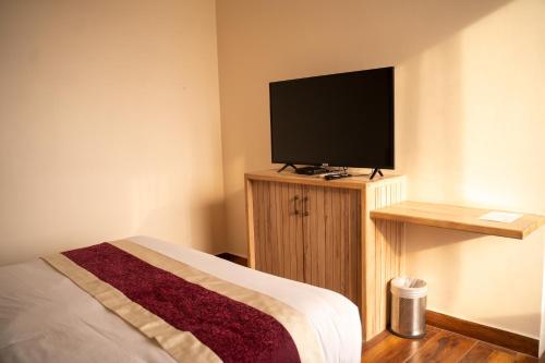 a bedroom with a flat screen tv and a bed at Hotel Black Diamond - Transit Point Inside Hotel in Kathmandu