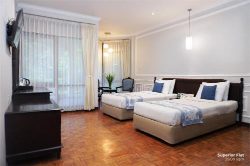 Postel nebo postele na pokoji v ubytování Puteri Gunung Hotel