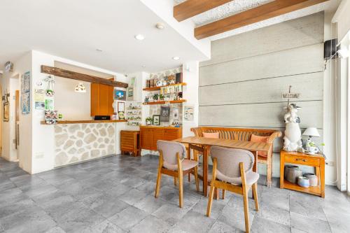 eine Küche und ein Esszimmer mit einem Holztisch und Stühlen in der Unterkunft Fairyland & Farm Guest House in Kenting
