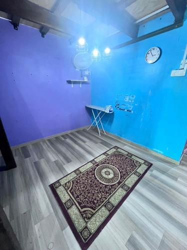 a room with a rug on the floor with a clock at NSAFF Homestay UTHM in Parit Raja