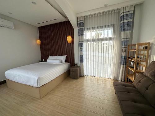 a bedroom with a bed and a couch at Experience Homestay in Can Tho