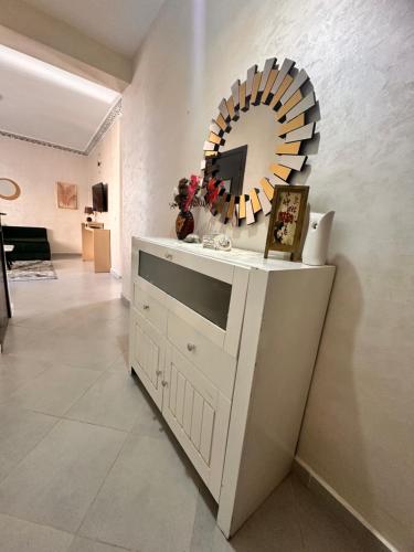 a white dresser with a mirror on a wall at Appart Neuf Calme et Proche in Branes
