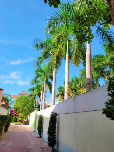 a white fence with palm trees in the background at Khách Sạn Đông Nam Á 2 in Ben Tre