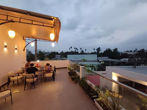 a group of people sitting at a table on a balcony at Experience Homestay in Can Tho