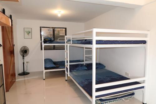 a room with three bunk beds in a room at Puting Bakod- Vacation Home with Mountain & Lake View in Jalajala