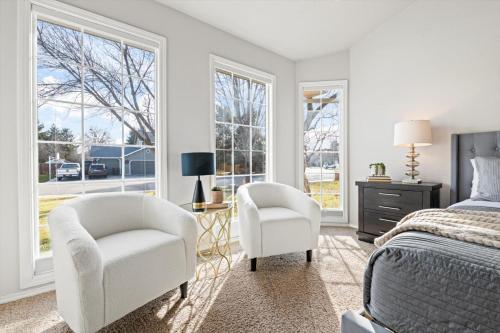 a bedroom with two chairs and a bed and windows at Group-ready 5br Fire Pit Bbq Topgolf Coupons in Meridian
