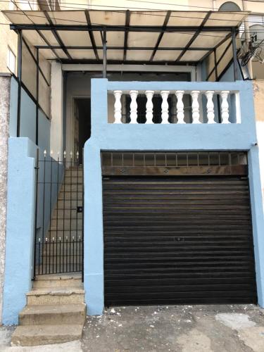a building with a garage door and a balcony at Residência Ruiz Conforto moderno e elegante em São Paulo in Sao Paulo