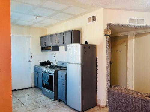 a kitchen with a white refrigerator and blue cabinets at Bienvenidos a la casa gris in Tolentino