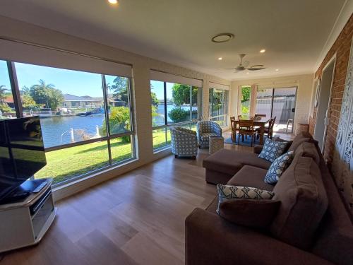 a living room with a couch and a flat screen tv at Castaway on King George in Forster