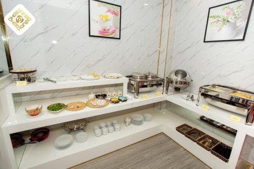 a kitchen with white shelves with food on them at Hoa Hồng Hotel 2 - Xã Đàn in Hanoi