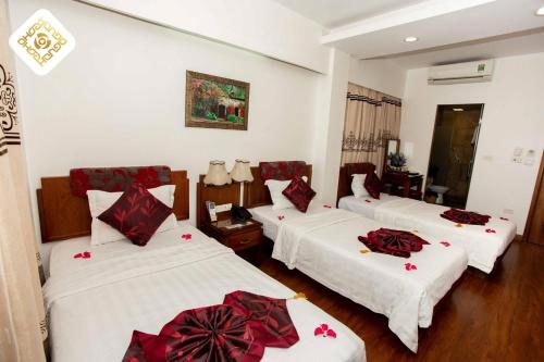 a room with three beds with red bows on them at Hoa Hồng Hotel 2 - Xã Đàn in Hanoi