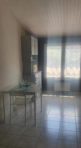 - une cuisine avec une table et 2 fenêtres dans une pièce dans l'établissement Studio indépendant 27m2 Sanary sur Mer, à Sanary-sur-Mer