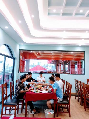 a group of people sitting at a table in a restaurant at Texas Corner Garden Resort in Xóm Tram