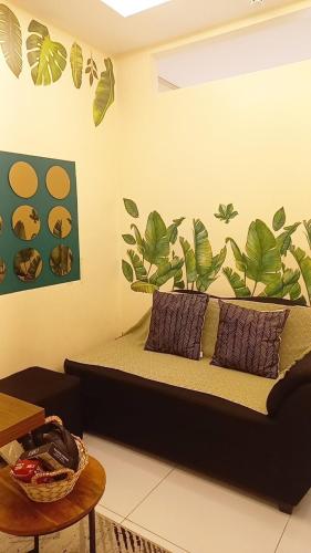 a bedroom with a bed with leaves painted on the wall at Cozy & comfy staycation in Quezon City in Manila