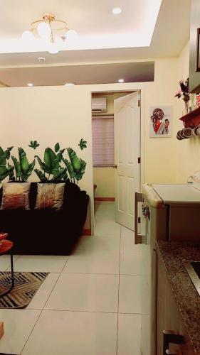 a living room with a black couch in a room at Cozy & comfy staycation in Quezon City in Manila