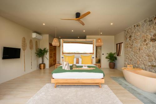 a bedroom with a large bed and a bath tub at Wild Cottages Elephant Sanctuary Resort in Amphoe Koh Samui