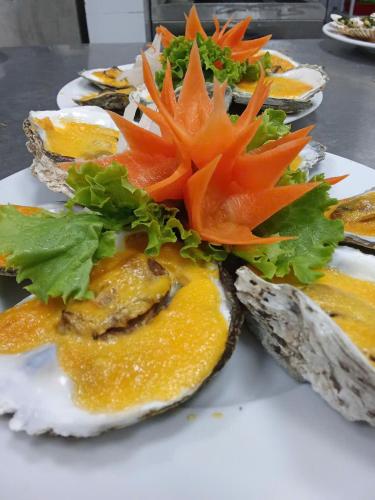 a plate of food with oranges and vegetables on it at Texas Corner Garden Resort in Xóm Tram
