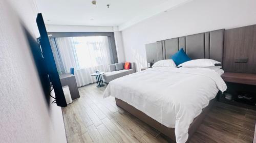 a bedroom with a large white bed and a couch at Bestway Hotel Xi'an in Xi'an