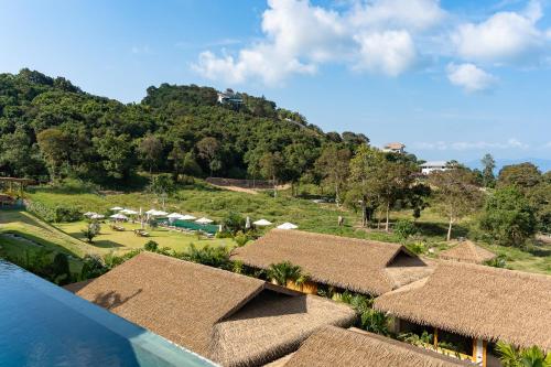 a view of a resort with a mountain in the background at Wild Cottages Elephant Sanctuary Resort in Amphoe Koh Samui