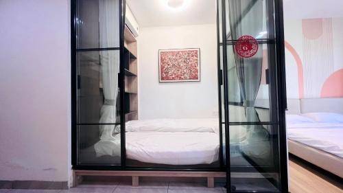a glass cabinet with a bed in a bedroom at House of Great White Apartment in Shenzhen