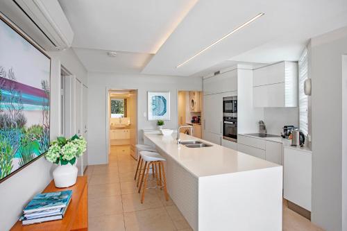a kitchen with white cabinets and a counter top at Picture Point Terraces in Noosa Heads