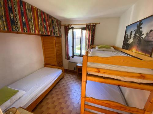 une chambre avec deux lits superposés et une fenêtre dans l'établissement Spacieux T3, 6 Pers. avec Terrasse et Parking entre Plage et Port - FR-1-798-16, à Leucate