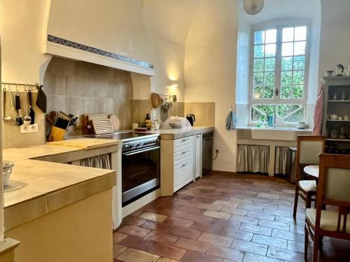 eine große Küche mit Herd und Fenster in der Unterkunft Elegant Town house-sleeps 14 in Saint-Hippolyte-du-Fort