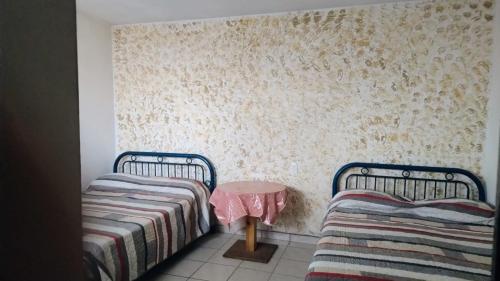 a bedroom with two twin beds and a table at Cuarto independiente doble in Culiacán
