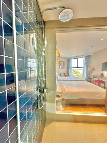 a bathroom with a mirror and a bed in a room at Khách Sạn Apec Mũi Né Phan Thiết in Ấp Thiẹn Ái